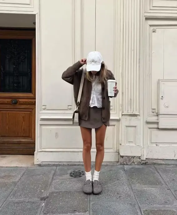Woman in a casual fall outfit with a skirt and cozy cardigan.