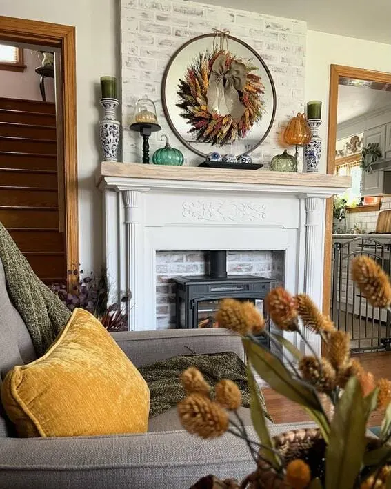Rustic fall mantel with a dried floral wreath and earthy decor.