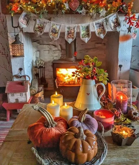 Cottage-style fall mantel with pumpkins, warm candlelight, and rustic autumn decor.