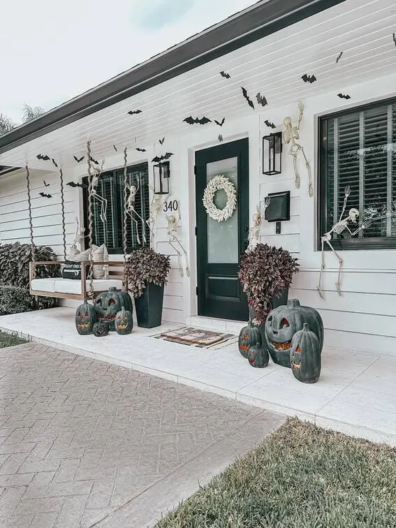 This porch brings Halloween mischief to life, with skeletons climbing the walls and hanging out on the swing, creating a playful yet eerie atmosphere.
