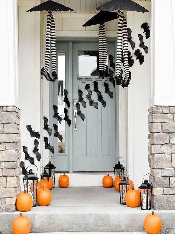 This porch takes Halloween to a whole new level of fun with two pairs of witch legs hanging upside down from floating black umbrellas, creating the illusion of witches crashing down mid-flight.