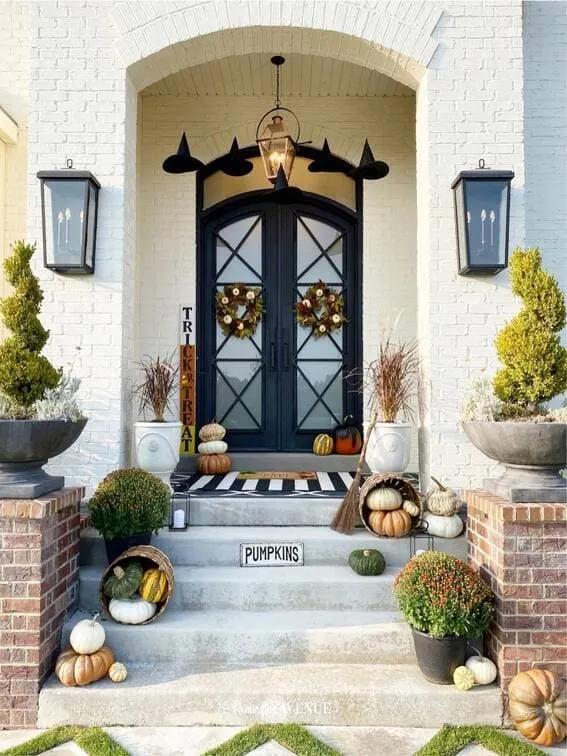 This porch features an elegant Halloween design with floating black witch hats hanging above a set of sophisticated double doors, creating a magical, whimsical effect.