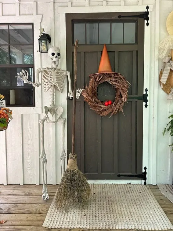 This porch keeps it spooky and minimalist, with a friendly skeleton waving at guests and a wreath topped with a witch hat for a magical flair.