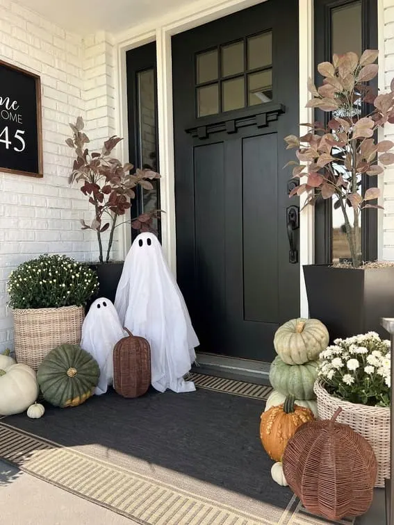 This porch embraces a soft, minimalist Halloween vibe with two adorable ghosts made from sheer fabric standing guard by the door.