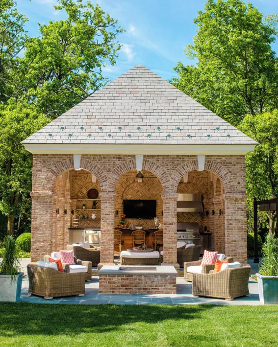 Beautiful brick pavilion that has an outdoor kitchen as well as a seating around the fire pit.
