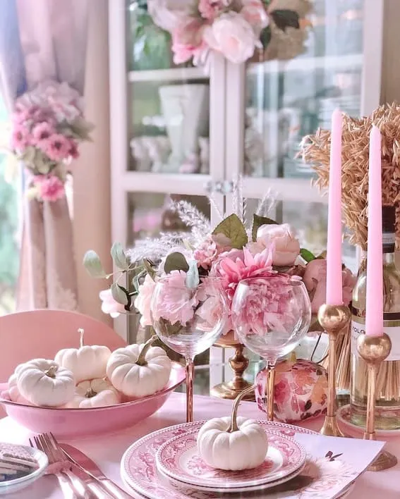 A soft, romantic fall tablescape featuring white mini pumpkins, pink florals, and elegant gold accents.