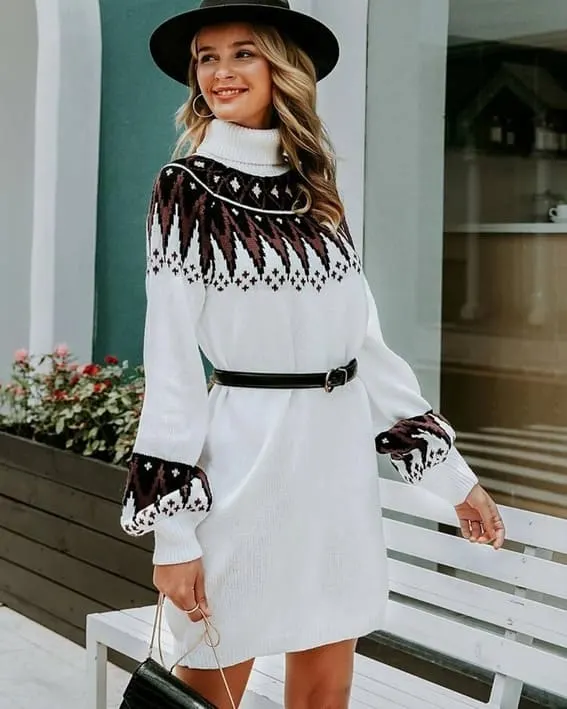 A woman is wearing the White Fair Isle turtleneck sweater dress with wide-brim hat and belt.